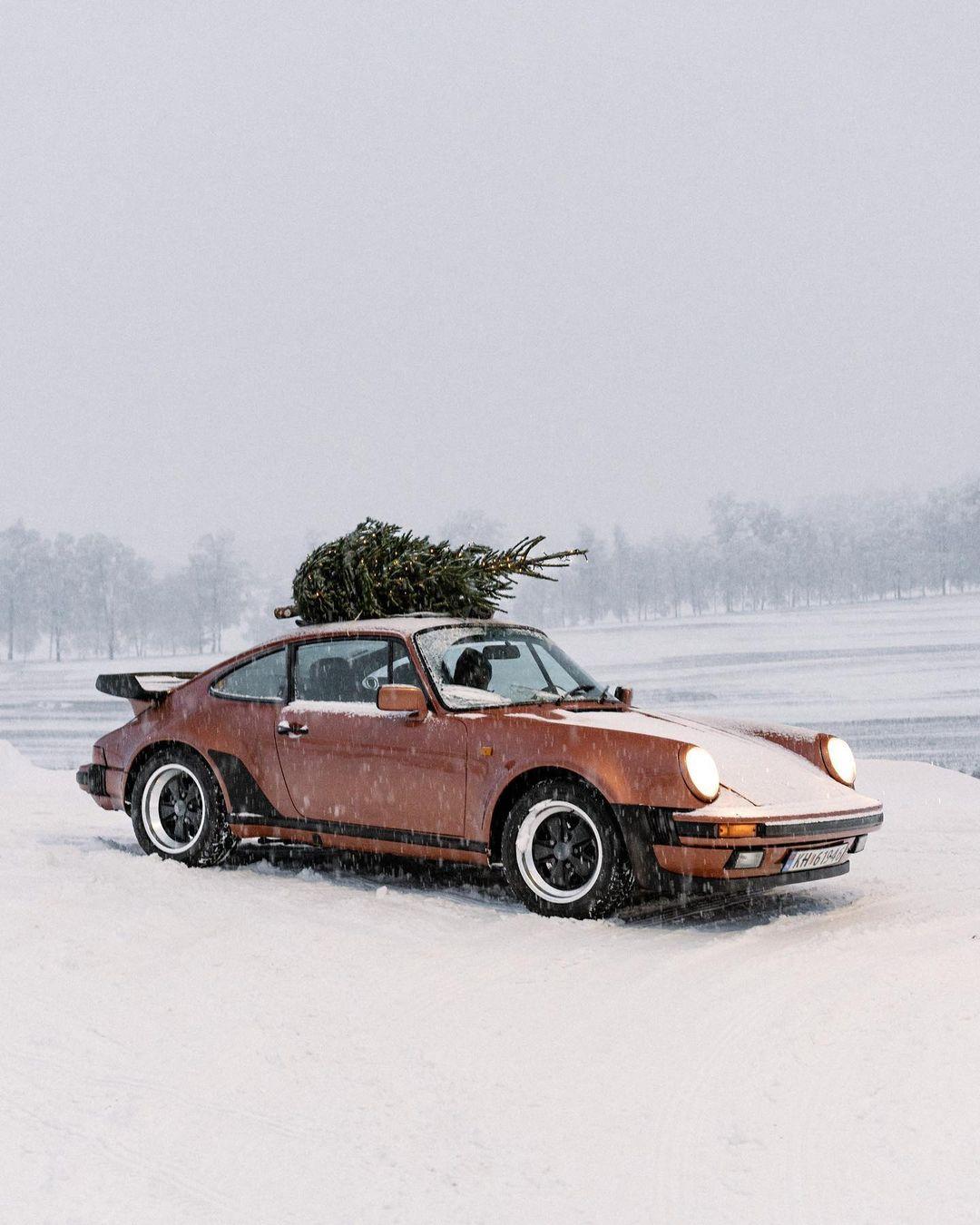 Retro-Sportwagen mit Weihnachtsbaum im Schnee, symbolisch für den jährlichen Kreislauf ausgelutschter Weihnachtslieder wie 'Last Christmas'.